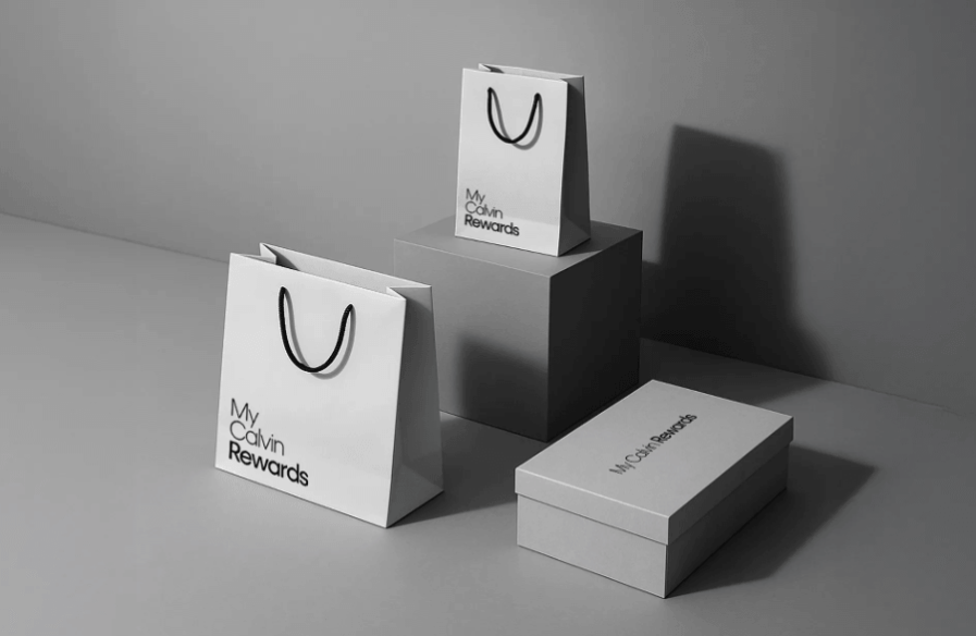 My Calvin Rewards branded shopping bags and gift box displayed in a minimalist monochrome product shot